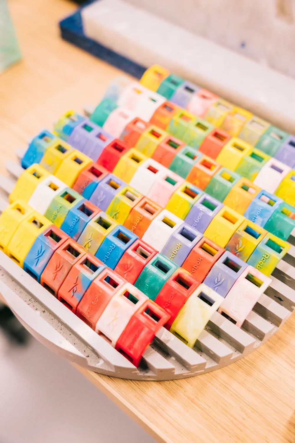 Goodies Reebok en plastique recyclé coloré, réalisés en atelier.